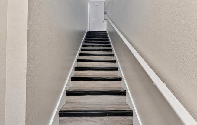 A staircase with wooden steps and white railings.