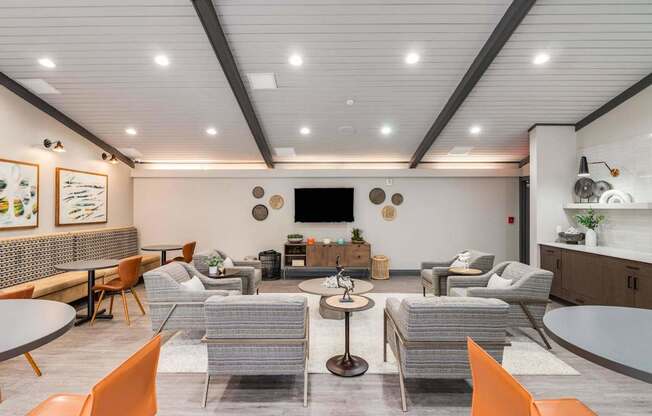 A modern living room with a grey sofa set, a coffee table, and a TV mounted on the wall.
