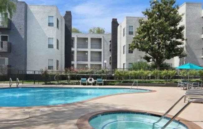 A swimming pool in front of apartment buildings.