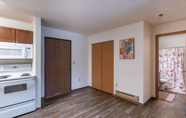 the view of a kitchen and living room with a white stove and refrigerator. Fargo, ND Parkwood