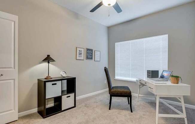 a bedroom with a desk and a chair and a window. Circle Pines, MN Lexington Lofts