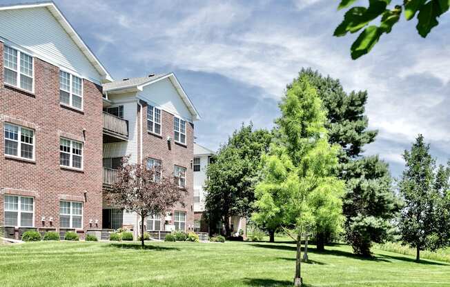 A large brick building with a white roof and a tree in front of it. at Tranquility Pointe, Nebraska, 68164