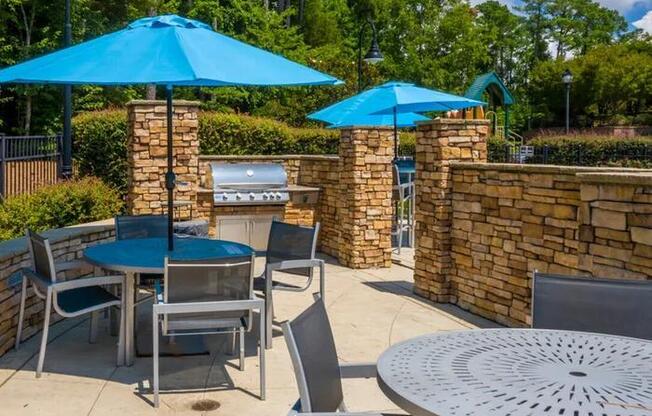 A patio with a table, chairs and umbrellas.