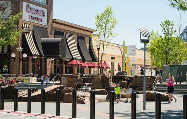 A restaurant with a red awning is located in a shopping center.