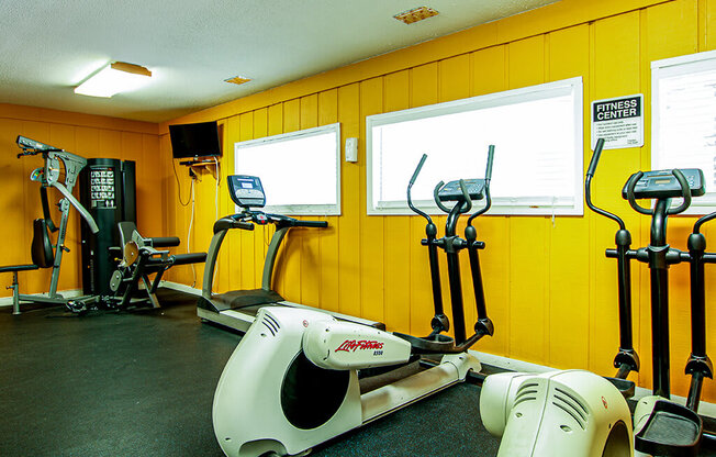 a gym with various exercise equipment in it