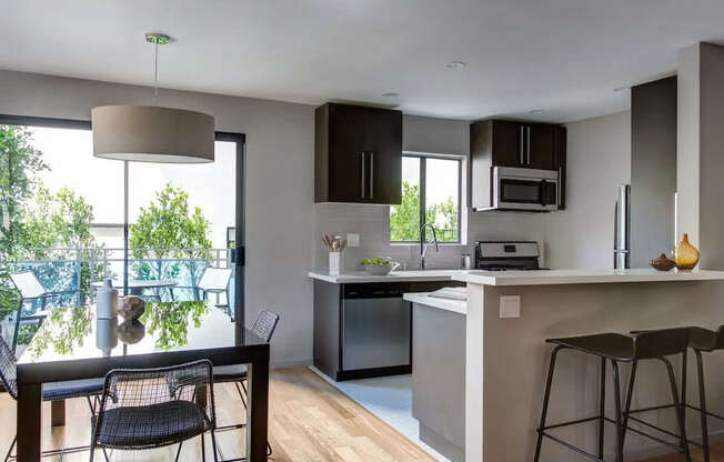 A kitchen with a bar stool and a table with chairs.