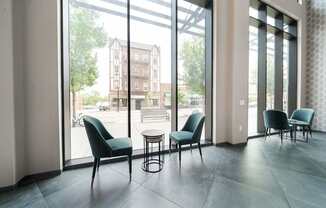 A room with a table and chairs in front of a large window.