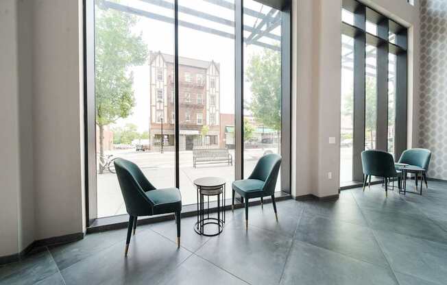 A room with a table and chairs in front of a large window.