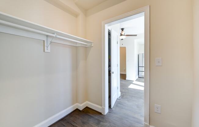 walk in closet with large shelf and wood flooring at petworth station apartments in washington dc