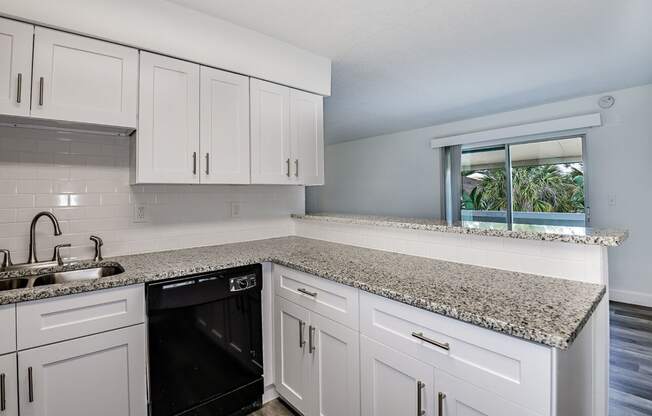 a kitchen with white cabinets and granite counter tops