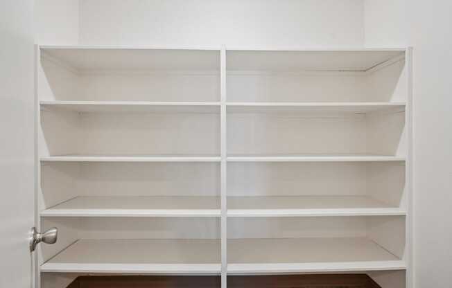 A white shelving unit with eight shelves is open.