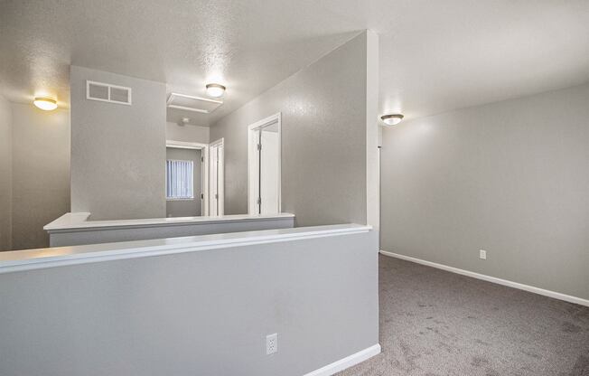 an empty living room with a white wall and a window