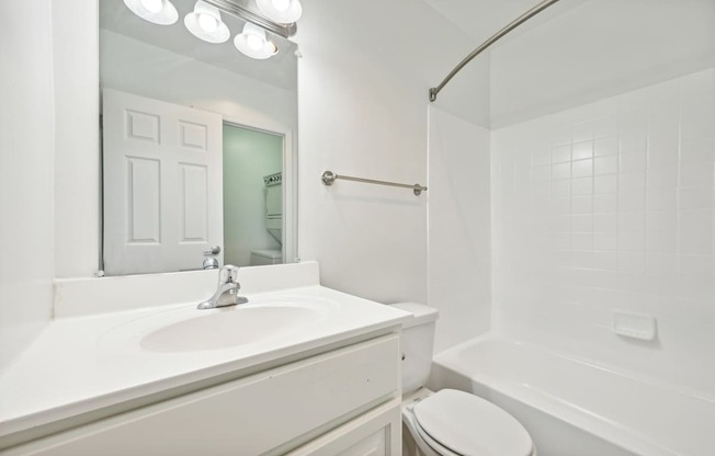 a white bathroom with a sink and a mirror at ReNew Odenton