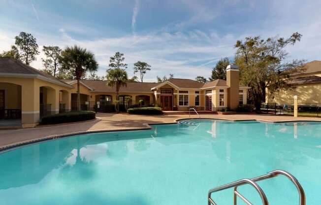 A swimming pool in front of a building with a metal ladder.