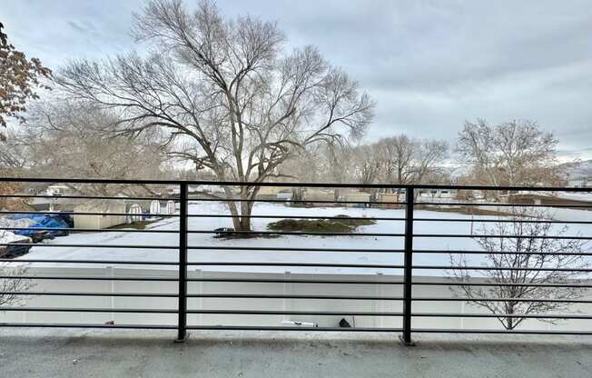 a view of a snow covered parking lot from behind a fence