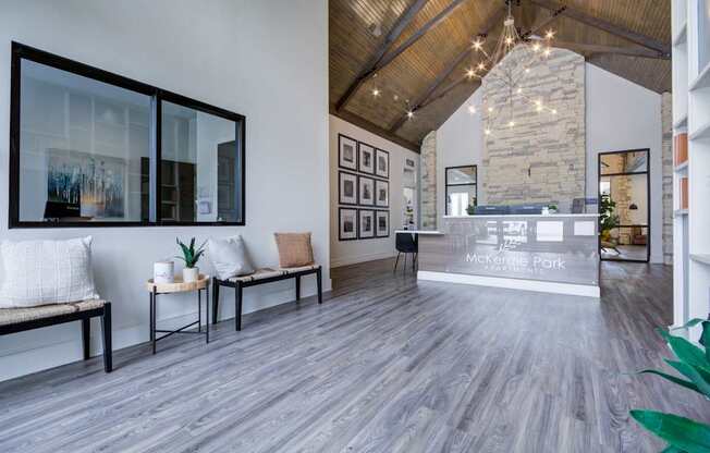A spacious lobby with a bench and a reception desk.
