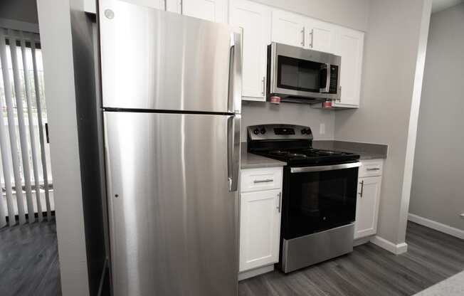 a kitchen with stainless steel appliances and white cabinets