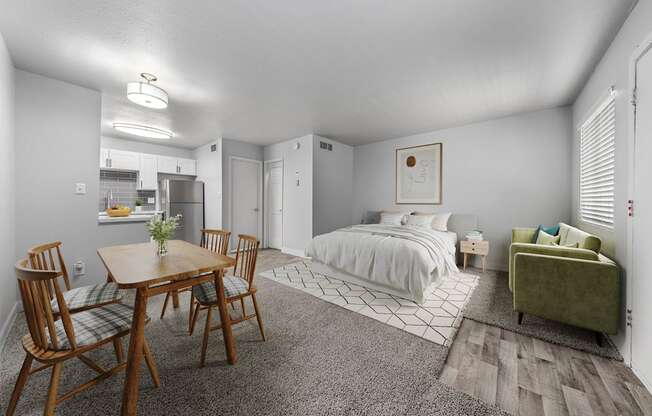 A bedroom with a bed, a couch, a table and chairs.