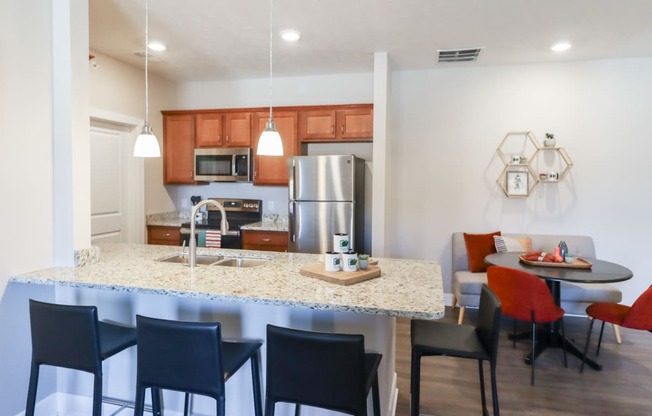 a kitchen and dining area with a granite counter top and stainless steel appliances