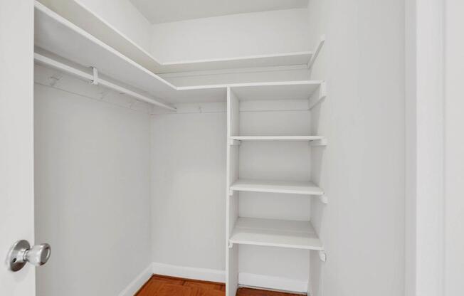 A white shelving unit in a room with a wooden floor.