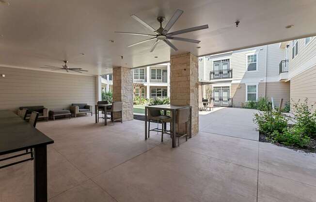 A patio with a table and chairs is surrounded by a building.