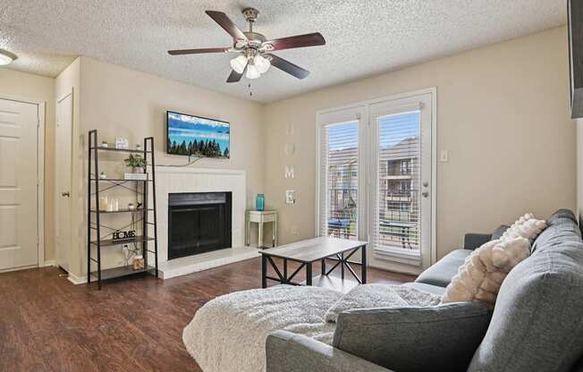 A living room with a grey couch and a fireplace.