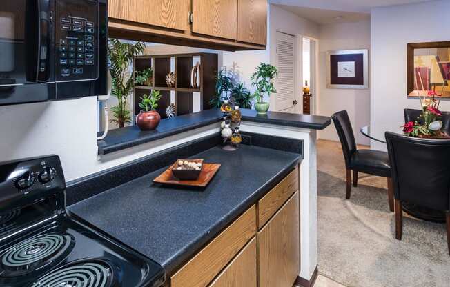 a kitchen with a stove top oven next to a table with a chair