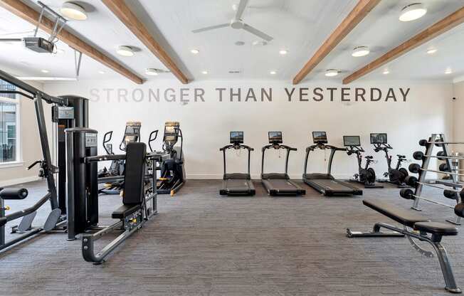 a gym with cardio machines and weights on the floor