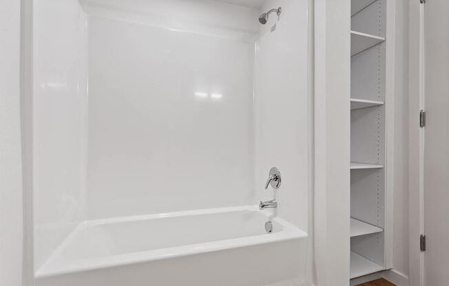 a white bathroom with a tub and a closet