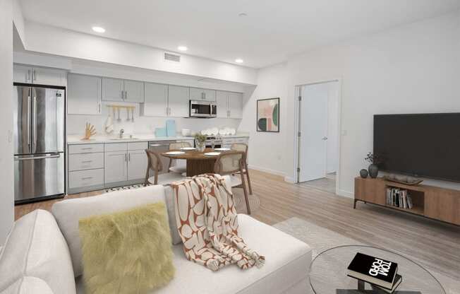 a living room with a couch and a table with a kitchen in the background