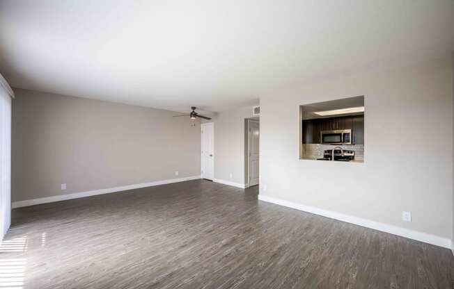 an empty living room with white walls and wood floors