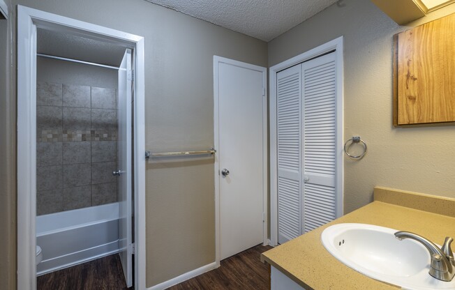 A bathroom with a sink, toilet, and shower.
