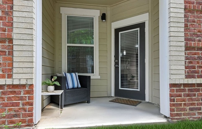 A house entrance with a bench and a door.