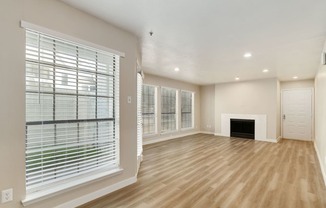 a living room with a fireplace and large windows