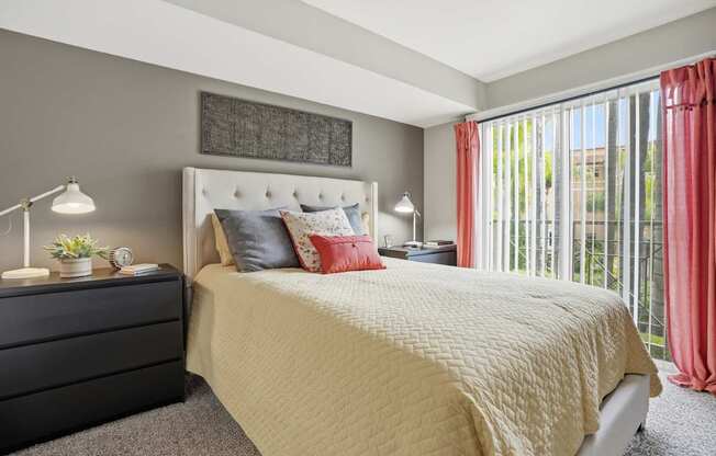 A bedroom with a large bed and a black dresser.
