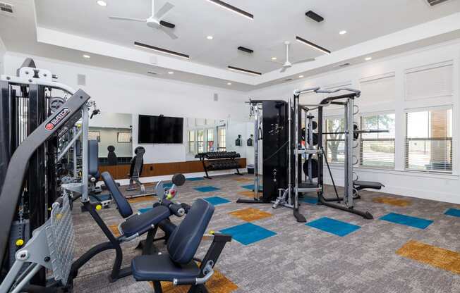 a gym with exercise equipment and a television
