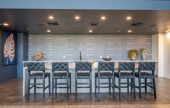 a large table with chairs in front of a wall with a geometric pattern