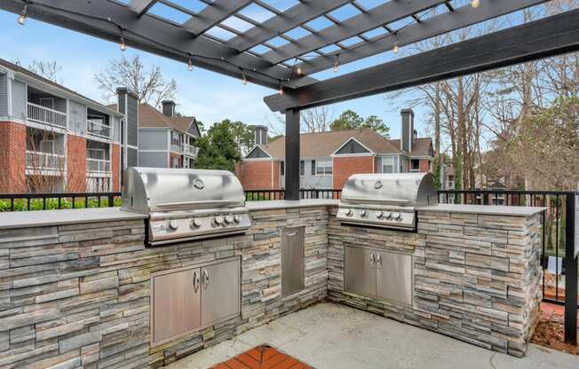 two stainless steel barbecue grills on a patio with a pergola at Madison Brookhaven, Atlanta, 30329