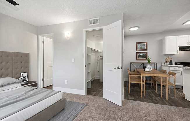 Model Studio Bedroom with Carpet and View of Dining Room at Stillwater Apartments in Glendale, AZ.