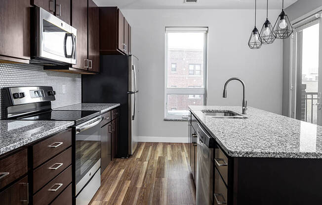 a kitchen with granite countertops and dark wood cabinets