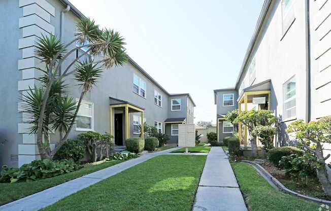 A row of houses with a sidewalk in front.