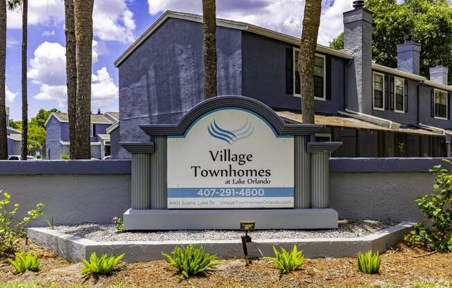 a village townhomes sign in front of a house