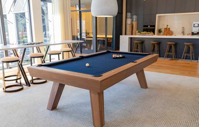 A pool table with a blue felt cloth is in the center of the room at Portofino Vineyards, Fort Myers