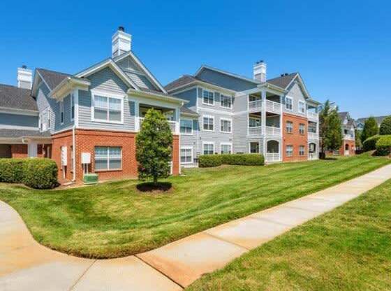 A large apartment complex with a well-maintained lawn in front.