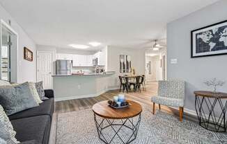 A living room with a grey couch, a coffee table, and a chair.
