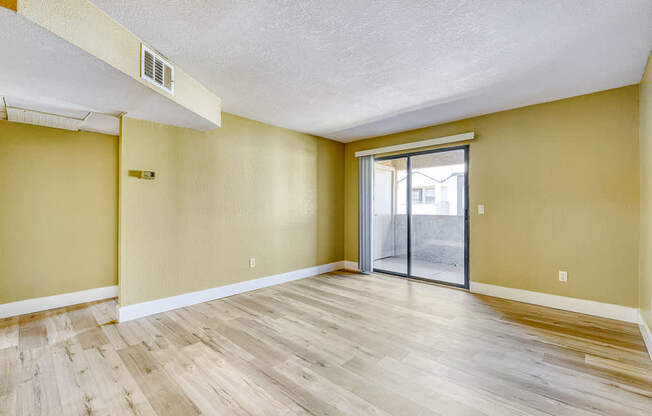 the spacious living room with sliding glass door to the patio
