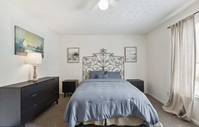 a bedroom with a bed and a dresser and a window