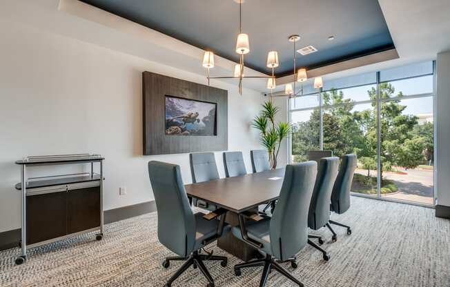 a conference room with a long table and chairs and a window