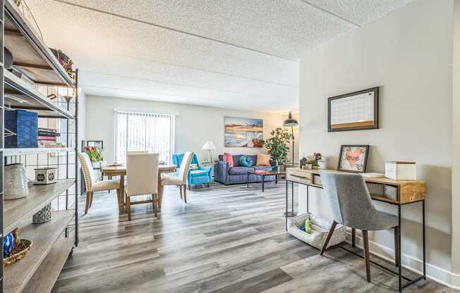 A living room with a blue couch and a wooden desk.