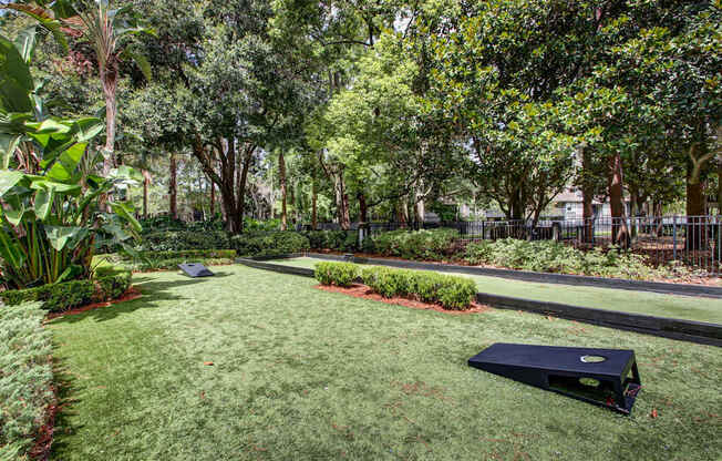 A black object is on the grass in a well kept garden.